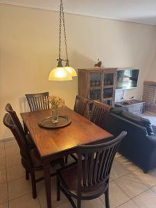 a dining room with a wooden table and chairs at GK23 Sea View House in Anavyssos