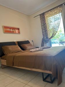 a bedroom with a large bed with a window at GK23 Sea View House in Anavyssos