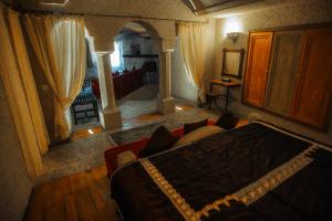 an aerial view of a bedroom with a bed and a couch at Anatolian Houses Cave Hotel & SPA in Göreme