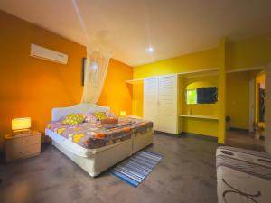 a bedroom with yellow walls and a bed in a room at Alha Villa in Baie Lazare Mahé