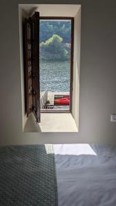 a room with a window looking out at the water at Casa rural A Fonte, Balneario Histórico de Cortegada in Cortegada