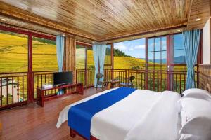 a bedroom with a bed and a balcony with a tv at Longji Forest Lodge--Terraced landscape from the room, Pick-up and drop-off service from Ping'an Village Parking Lot, Sunrise& Sunset in Heping +55 photos