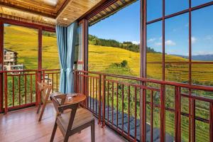 a room with a balcony with a view of a field at Longji Forest Lodge--Terraced landscape from the room, Pick-up and drop-off service from Ping'an Village Parking Lot, Sunrise& Sunset in Heping