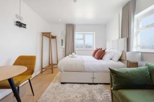 a white bedroom with a bed and a table at The Forest-Wildwood in Cambridge