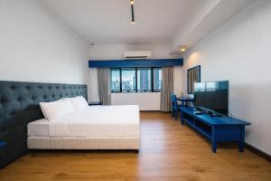 a bedroom with a bed and a desk and a television at 103 Hotel by manatidur in Kuala Lumpur