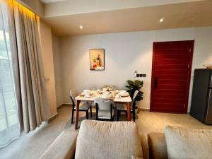 a dining room with a table and a red door at Masaki Cozy Stay in Dar es Salaam