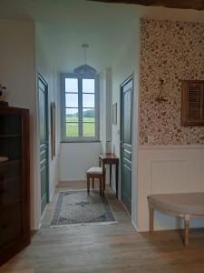 a hallway with green doors and a table and a window at Chambre d'hôtes - Retour à la ferme in Verteillac