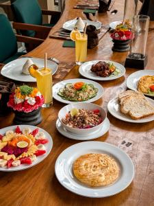 a wooden table with plates of food on it at Villa Kalisha - Romantic, Seclusion in the heart of Nature in Tegalalang