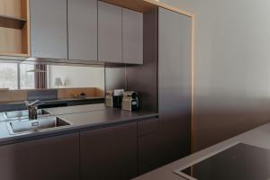 a kitchen with white cabinets and a sink at RELAX APARTMENTS An der Lage Hochgraßnitzberg in Spielfeld +180 photos