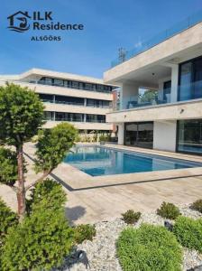 a building with a swimming pool in front of a building at ILK Residence 1 in Alsóörs