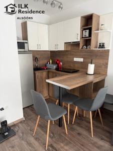 a kitchen with a wooden table and chairs at ILK Residence 1 in Alsóörs