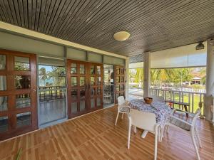 a dining room with a table and chairs on a porch at The Rich Instantly Home in Sathani Huai Yang
