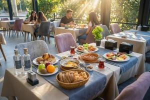 a table with food and people sitting at tables in a restaurant at Casa Ayris Boutique Hotel in Mersin