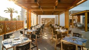 a dining room with wooden tables and chairs at Mitsis Faliraki in Faliraki