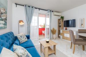 a living room with a blue couch and a table at Apartments Mare in Punat