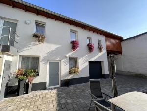 a white building with flowers on the side of it at Ferienwohnung Nestblick in Weilburg
