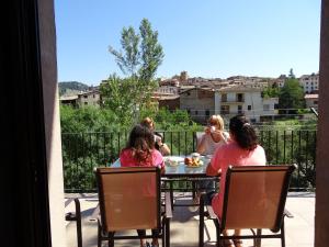 a group of women sitting at a table on a balcony at Casa Ombrieta in Beceite