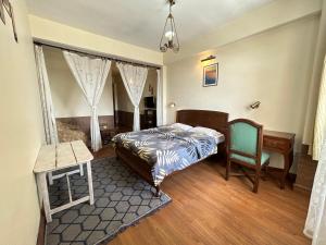 a bedroom with a bed and a desk and a chair at Lloyd's Vintage Home in Bhowāli