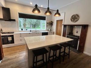 a kitchen with a large island with bar stools at Amberley Lodge in Amberley