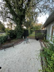 a patio with a table and a bench and a tree at Amberley Lodge in Amberley