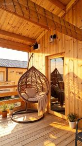 a wicker chair sitting on a wooden deck at chemtan cottages in Dushetʼi