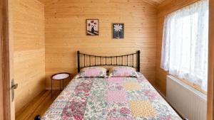 a bedroom with a bed in a wooden wall at chemtan cottages in Dushetʼi