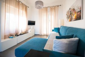 a living room with a blue couch and a tv at Casa Leucosia in Capri