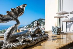 a statue of a mermaid sitting on a rock on a table at Casa Leucosia in Capri