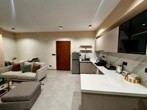 a kitchen and living room with a couch and a table at Masaki Cozy Stay in Dar es Salaam +39 photos