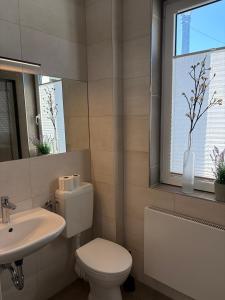 a bathroom with a toilet and a sink and a window at Feriennest am Meer Warnemünde in Warnemünde