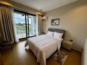 a bedroom with a bed and a large window at Masaki Cozy Stay in Dar es Salaam