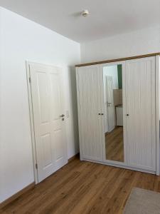 an empty room with a mirror and white walls at Feriennest am Meer Warnemünde in Warnemünde