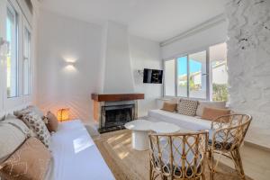 a living room with a couch and a fireplace at Urbanización El Oasis, 20 Villas en 1ª Línea Playa in Denia +190 photos
