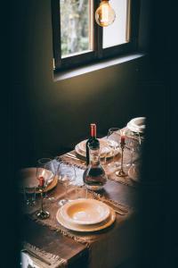 a table with glasses and a bottle of wine on it at 18Th-Century Stone House By River In Romagna in Sarsina