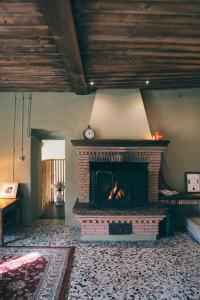 a living room with a brick fireplace with a clock at 18Th-Century Stone House By River In Romagna in Sarsina +31 photos