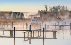 a body of water with a boat and houses at Haus Hallon in Wandlitz