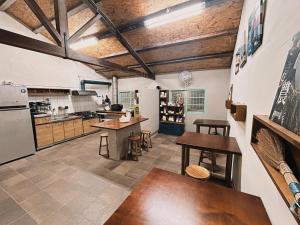 a large kitchen with wooden ceilings and wooden tables at 楊桃墅民宿 in Chishang
