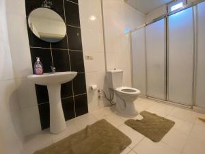 a bathroom with a sink and a toilet and a mirror at Daily airport aparthotel in Taşoluk