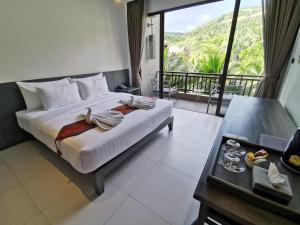 a bedroom with a bed with a view of a mountain at Maehaad Bay Resort - SHA Plus in Mae Haad +42 photos