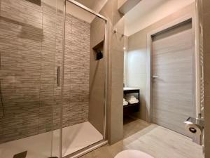 a shower with a glass door in a bathroom at HOMIA guest house by MOH in Grottaglie