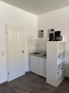 a small kitchen with a white door and a sink at Feriennest am Meer Warnemünde in Warnemünde +5 photos