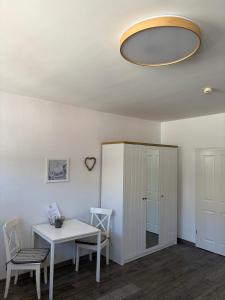 a room with a table and chairs and a cabinet at Feriennest am Meer Warnemünde in Warnemünde