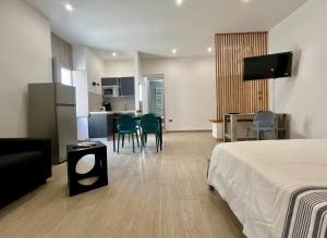 a hotel room with a bed and a kitchen at HOMIA guest house by MOH in Grottaglie