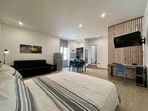 a bedroom with a bed and a living room at HOMIA guest house by MOH in Grottaglie