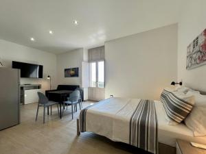 a bedroom with a bed and a living room with a table at HOMIA guest house by MOH in Grottaglie