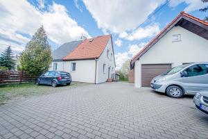 two cars parked in a driveway next to a house at Stara Piekarnia - Jagiellońska in Olsztyn