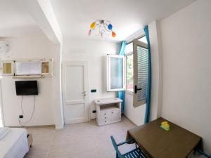 a small living room with a table and a desk at Maré Rooms Castro in Castro di Lecce