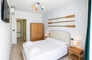 a bedroom with a white bed and a tv at Maré Rooms Castro in Castro di Lecce