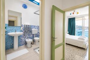 a bathroom with a sink and a toilet and a bed at Maré Rooms Castro in Castro di Lecce +18 photos