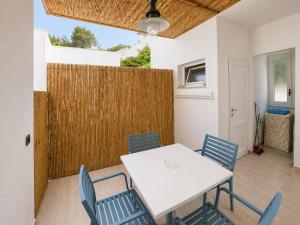 a dining room with a white table and blue chairs at Maré Rooms Castro in Castro di Lecce